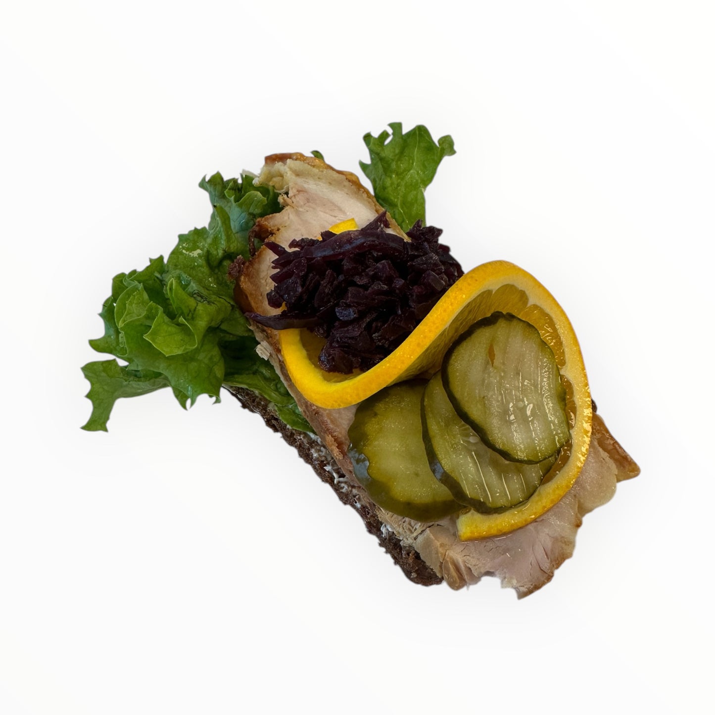 Flæskesteg med rødkål, syltede agurk og appelsin.