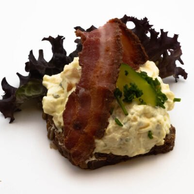 Æggesalat med agurk, purløg og bacon. Anrettes på dansk solsikke rugbrød