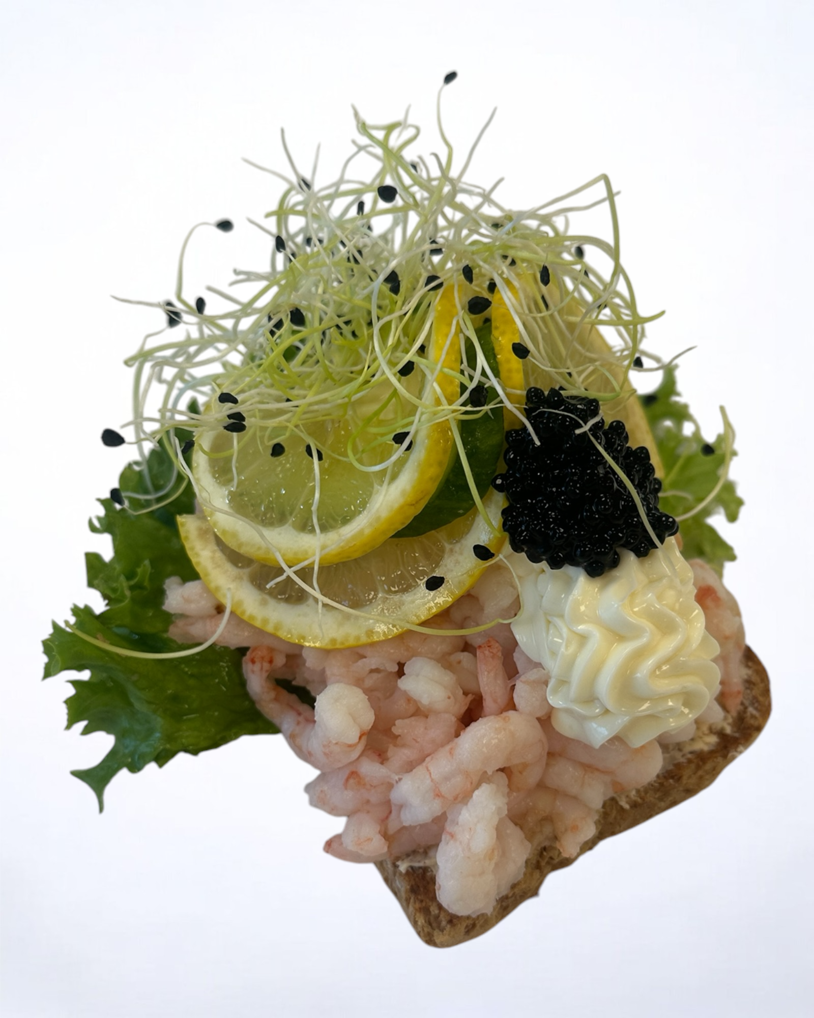 Luksus rejemad på lyst brød med citron, agurk, mayonnaise og sort kaviar