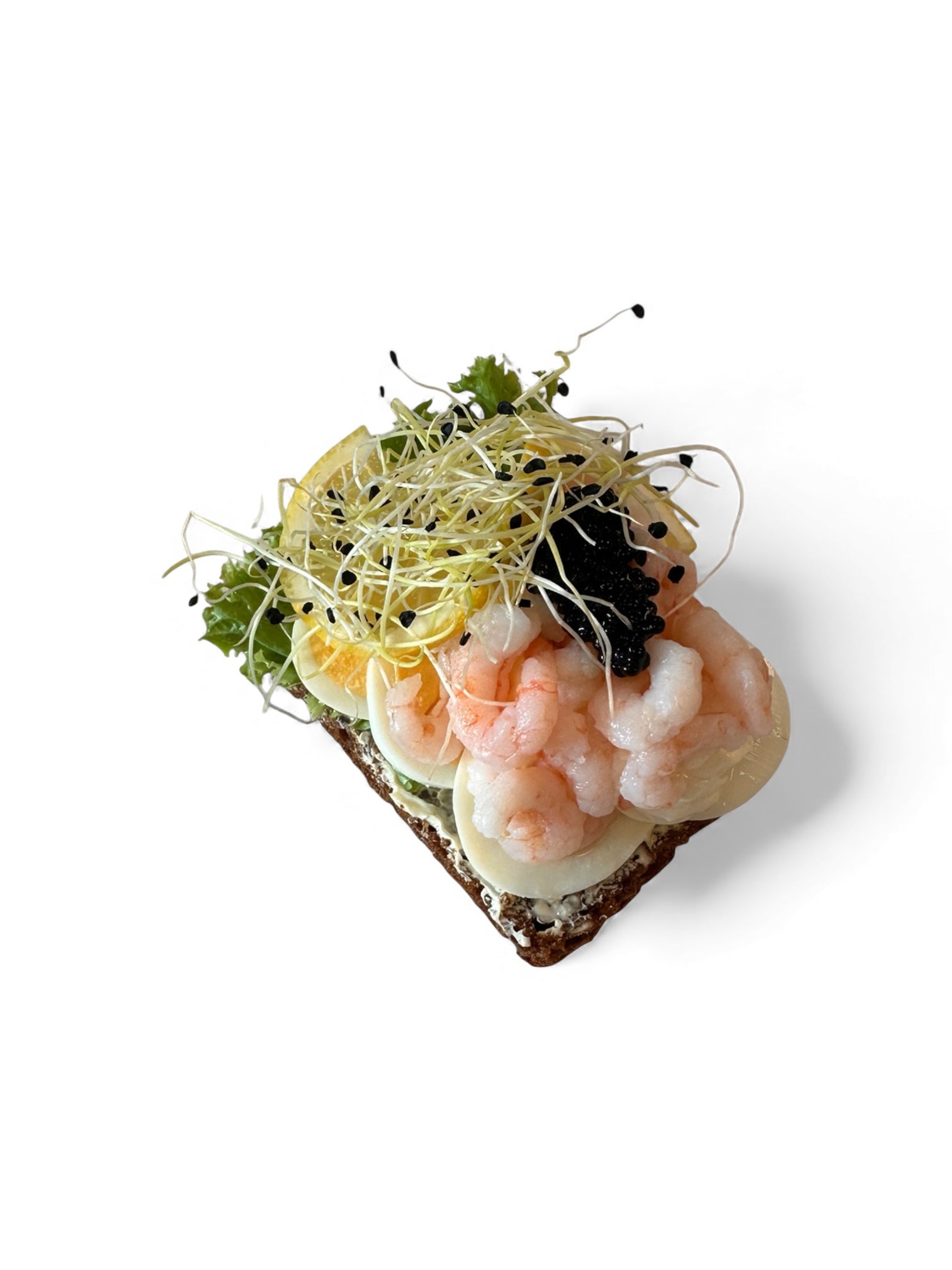 Æg og rejer med sort kaviar, citron og grønt på solsikkerugbrød