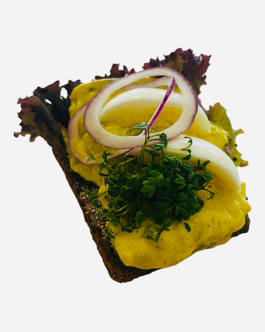 Dansk karry sild med rødløg, og æg pyntet med karse